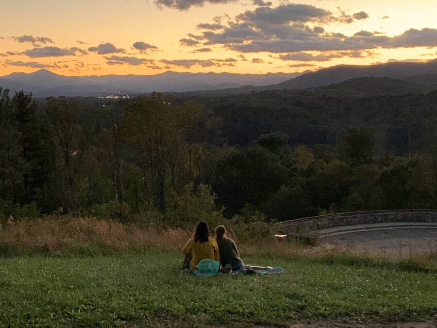 mountain sunset with 2 women on a grassy slope