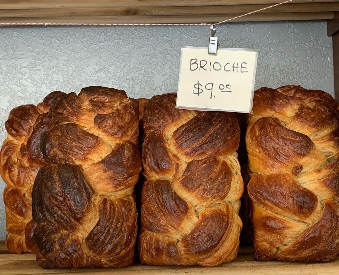 three loaves of brioche on their sides with a price of $9