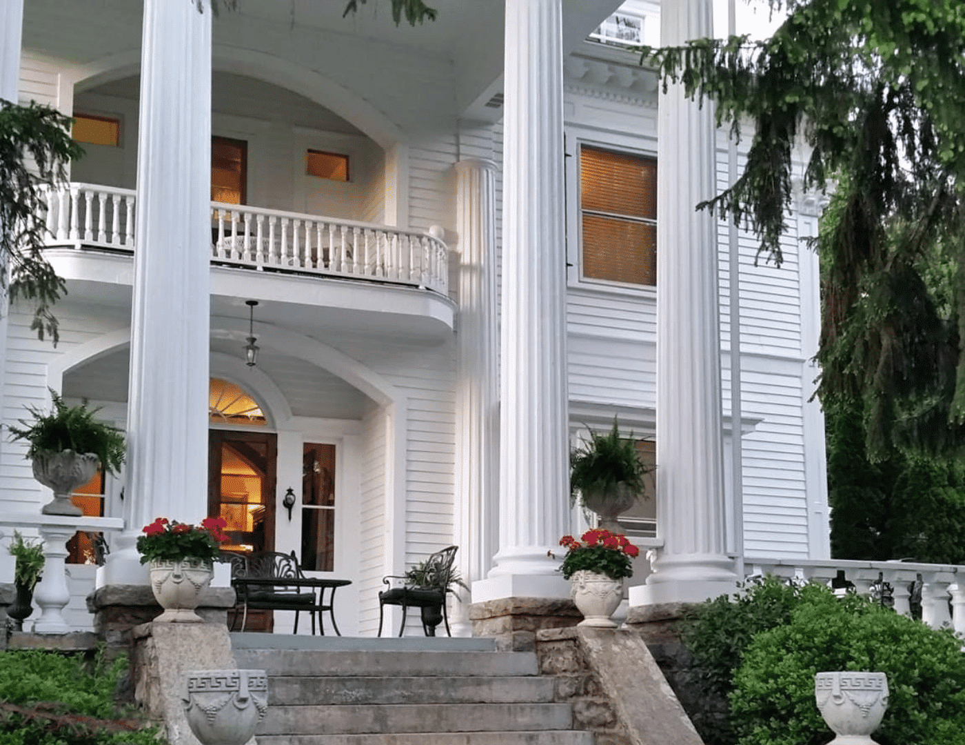 ext porch of b&b with stone steps, white columns, porch and patio furniture