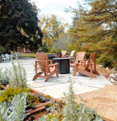a flagstone patio with adirondack chairs and a firepit