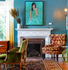 Art work girl picture over fireplace with a chair